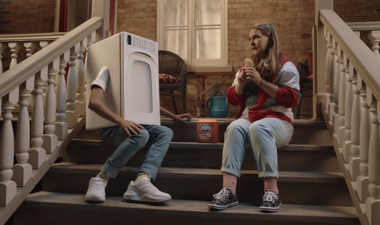 Lifestyle image of a woman and a a person with a microwave for a body sitting on stairs